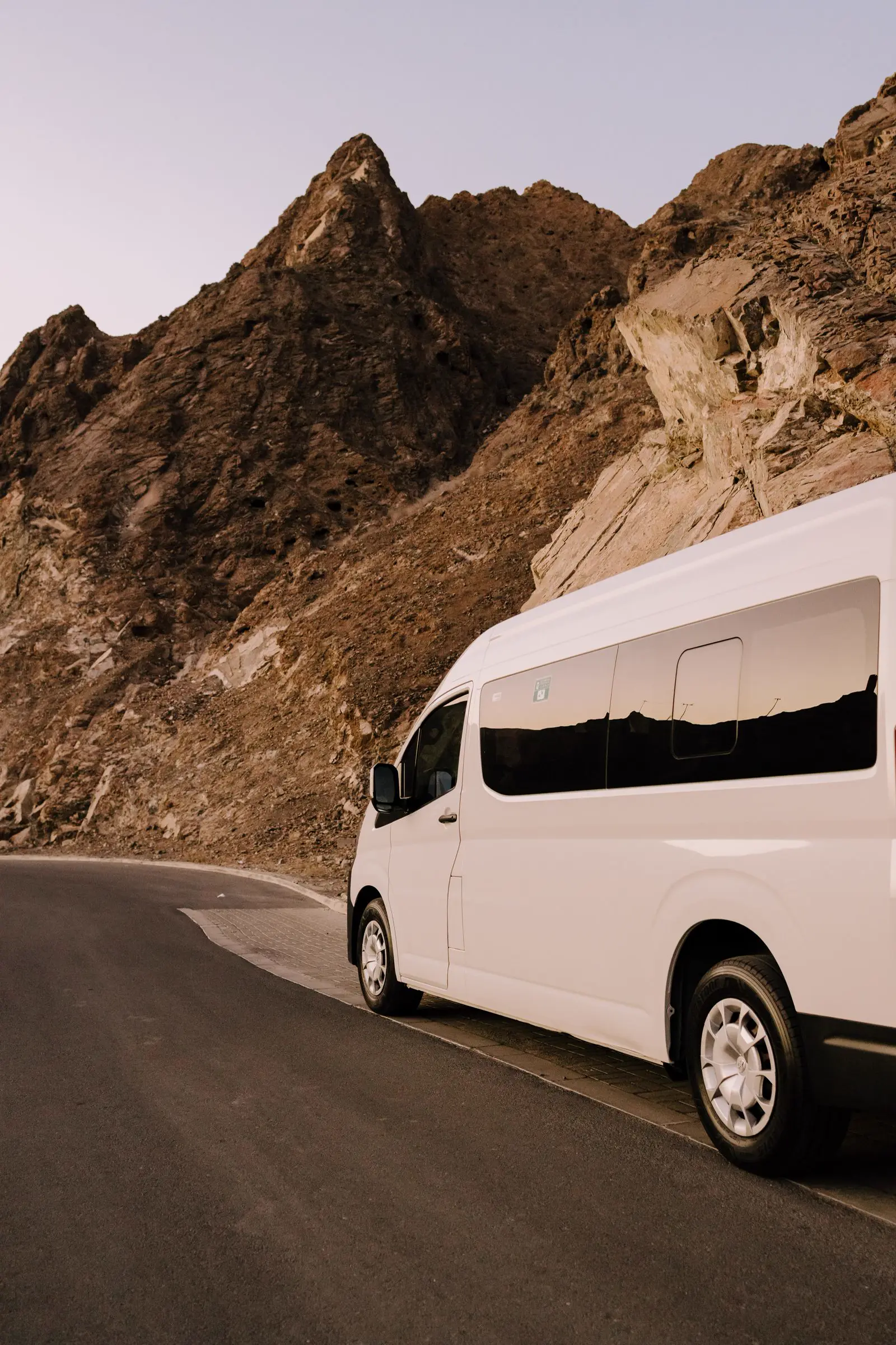 White Toyota HiAce van on a mountain road